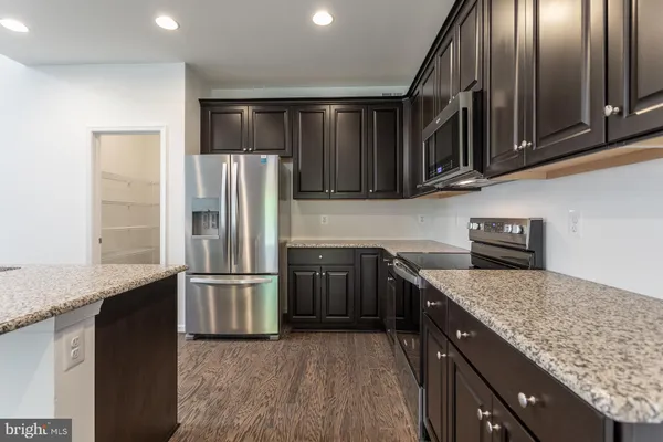 a kitchen with granite countertop stainless steel appliances and wooden cabinets