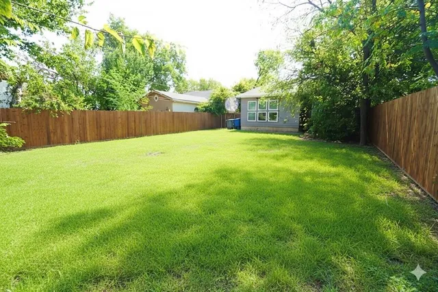 a view of a yard with a house and large trees