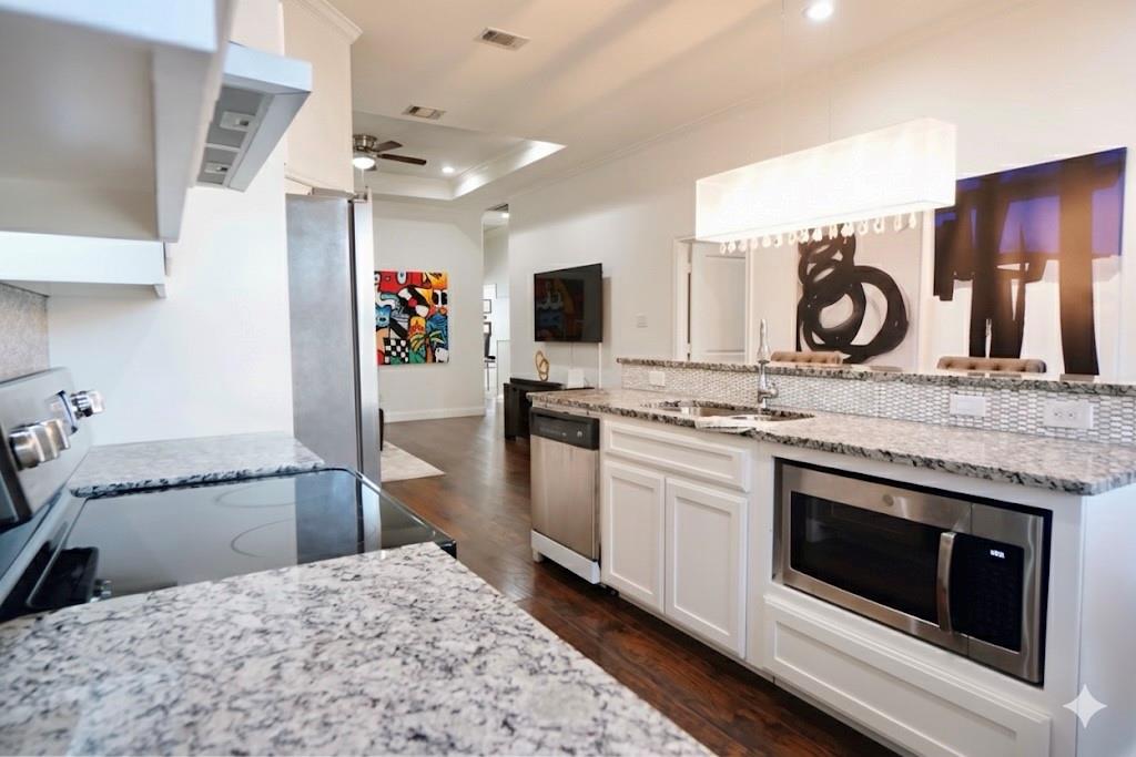 1439 Stella Avenue Dallas, TX 75216 - Photo 6 of 13 a kitchen with granite countertop a stove and a refrigerator
