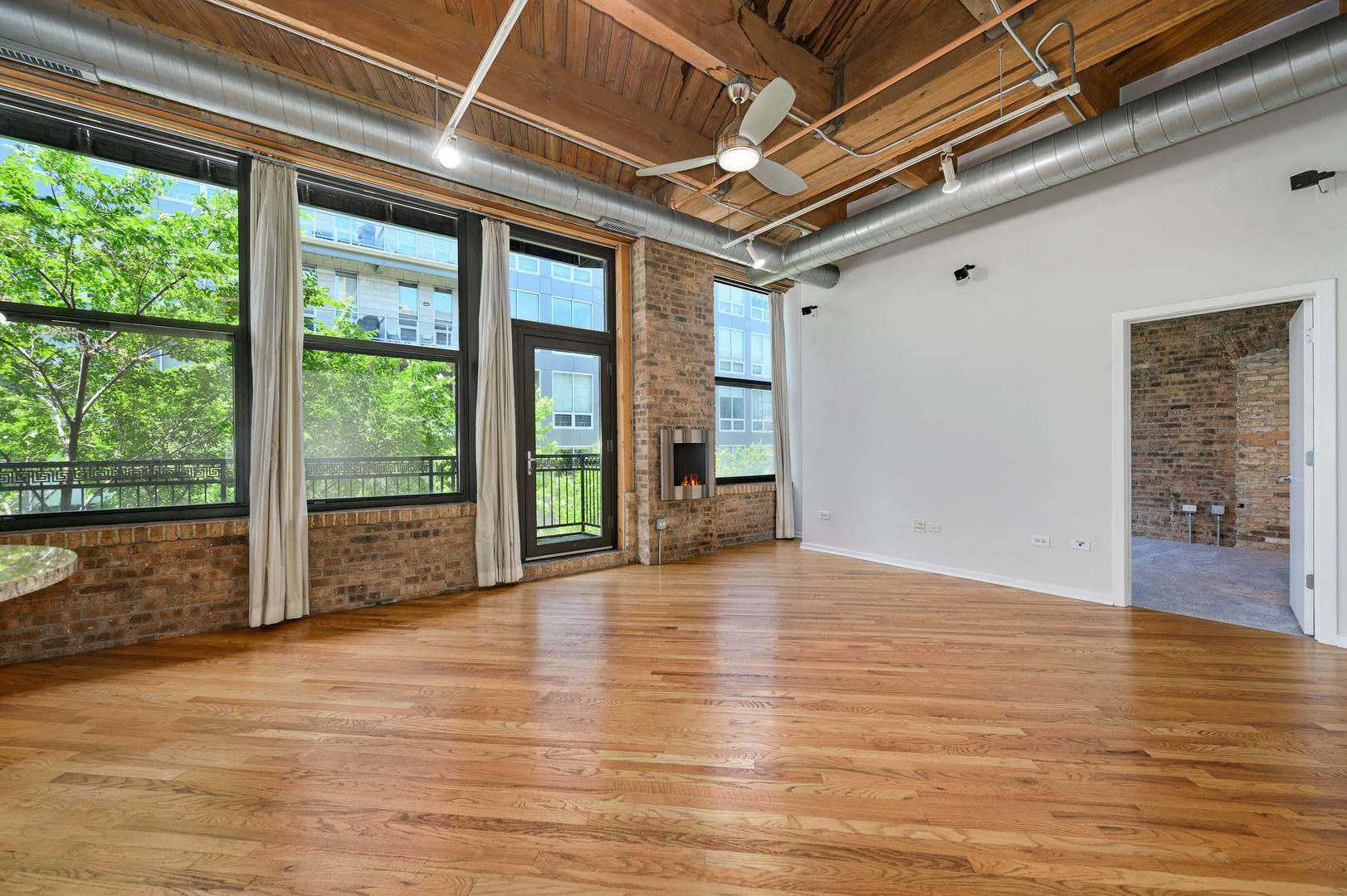 1040 West Adams Street, Unit 269 Chicago, IL 60607 - Photo 3 of 23 a view of an empty room with wooden floor and windows