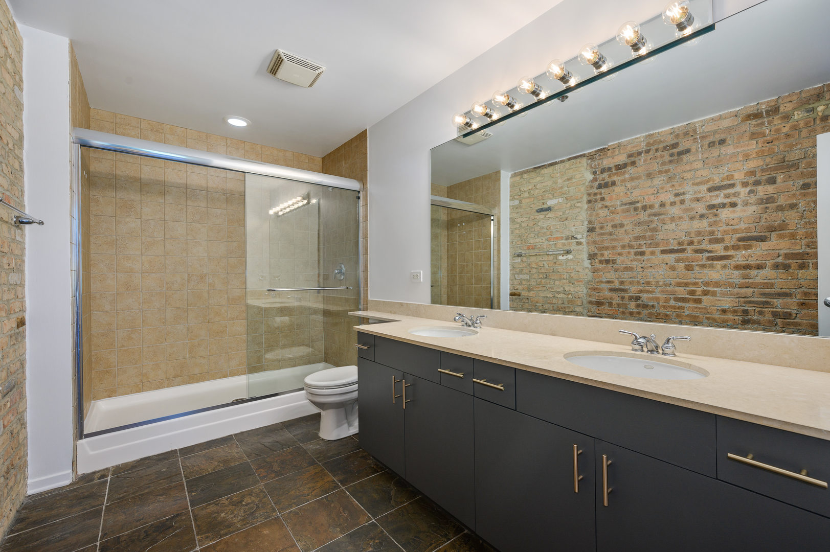 1040 West Adams Street, Unit 269 Chicago, IL 60607 - Photo 10 of 23 a bathroom with a double vanity sink toilet and shower