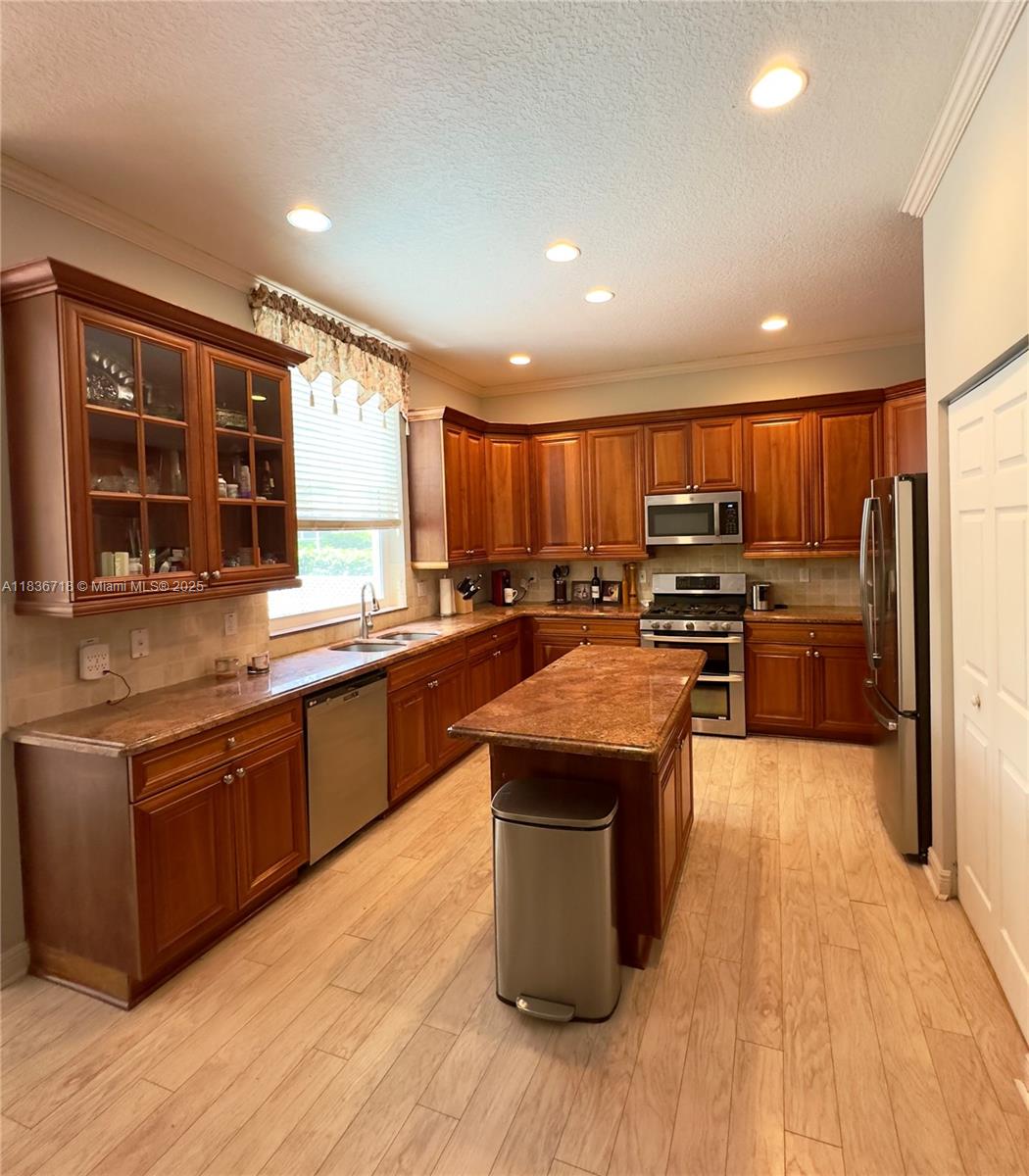 422 Oriole Circle Jupiter, FL 33458 - Photo 6 of 16 a kitchen with stainless steel appliances granite countertop a stove a sink dishwasher a refrigerator and a oven with wooden floors