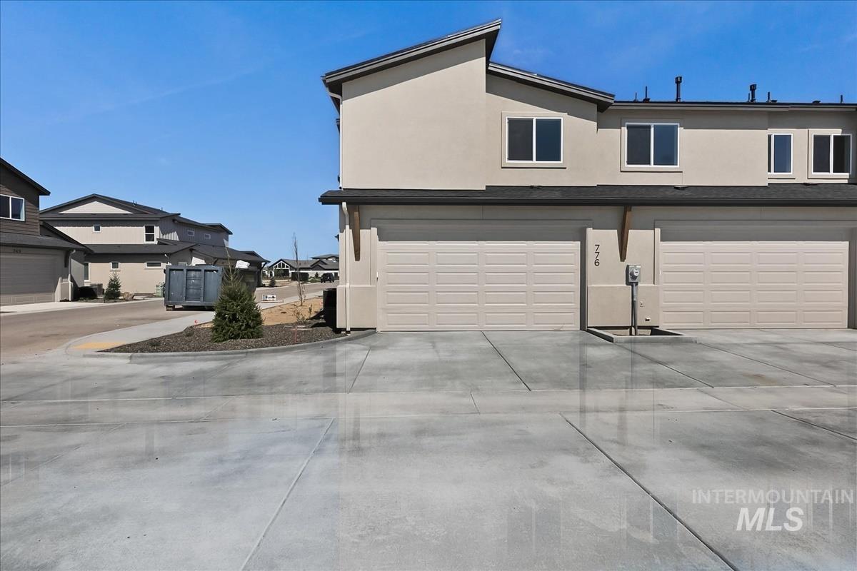 776 South Calhoun Lane Star, ID 83669 - Photo 44 of 49 Contemporary multi-story residence featuring light-colored stucco siding, multiple windows, and two attached garages with paneled doors
