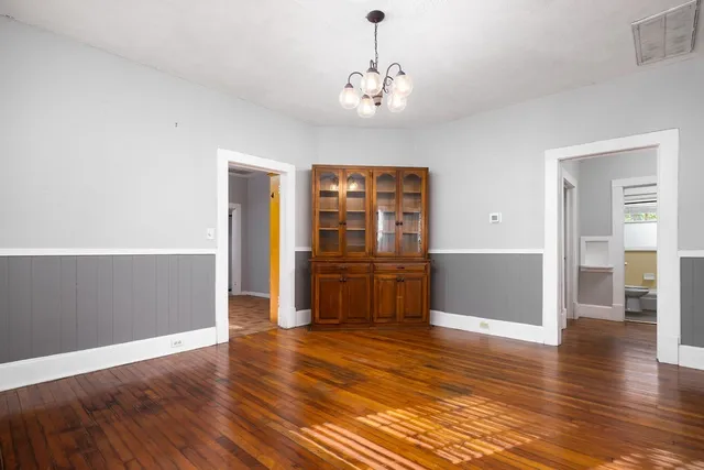 a view of a kitchen with wooden floor and cabinets