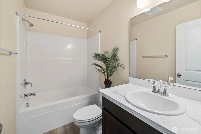 a bathroom with a granite countertop sink toilet a mirror a shower and a bathtub