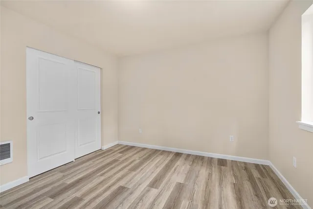 a view of an empty room with wooden floor