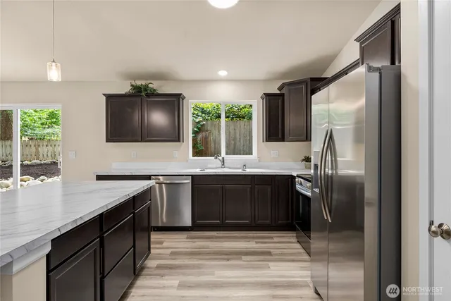 a kitchen with stainless steel appliances granite countertop a sink stove and refrigerator