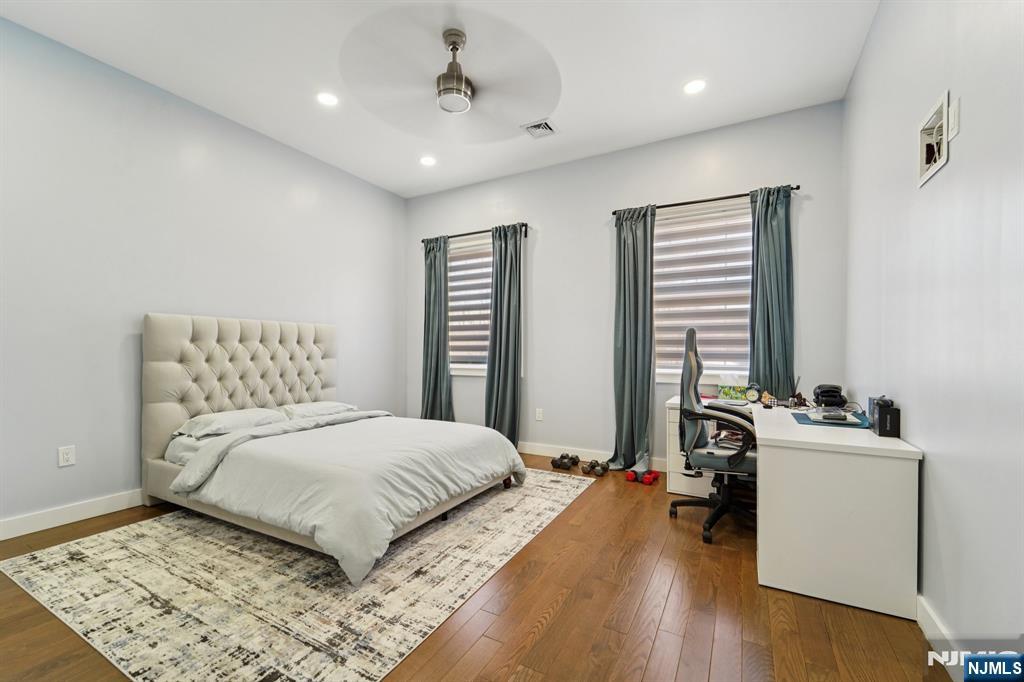 24 Holmes Lane Wayne, NJ 07470 - Photo 27 of 47 a bedroom with a bed a large window and wooden floor