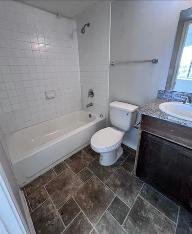 a bathroom with a granite countertop toilet a sink and bathtub
