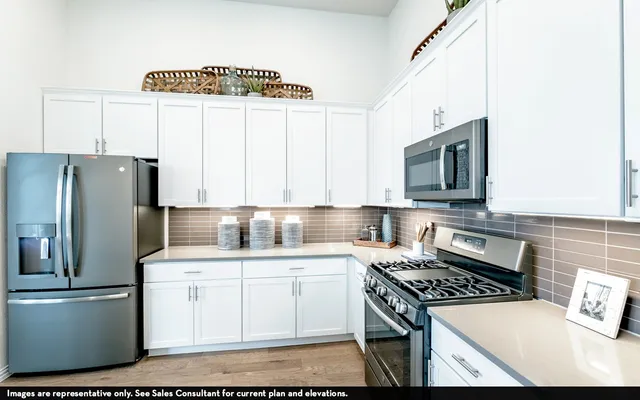 a kitchen with stainless steel appliances a stove a sink and a refrigerator