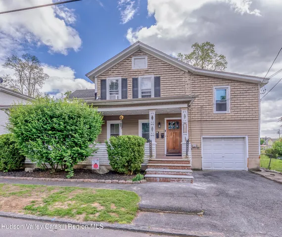 a front view of a house with a garden and plants
