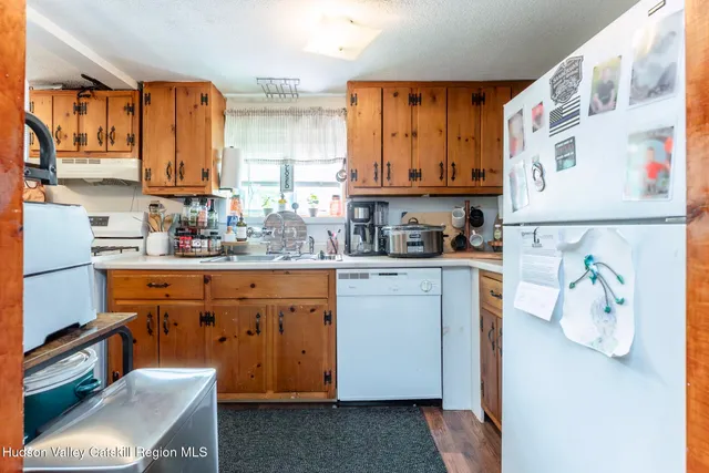 a kitchen with stainless steel appliances granite countertop a refrigerator sink and wooden cabinets