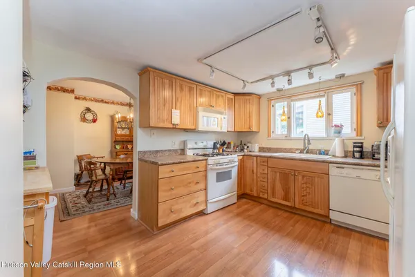 a kitchen with cabinets wooden floor and a window