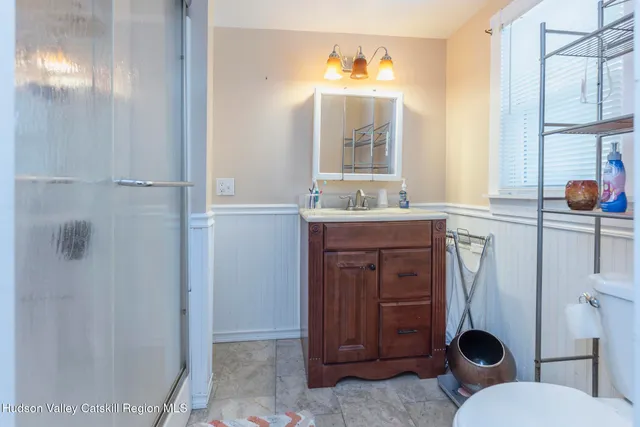 a bathroom with a toilet a sink and mirror