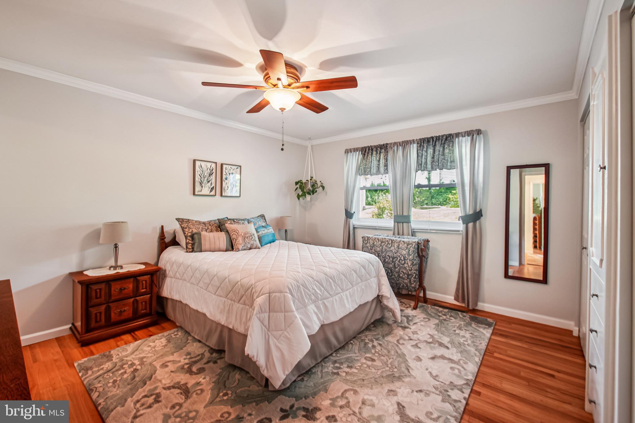 8113 Callo Lane Rosedale, MD 21237 - Photo 16 of 32 a bedroom with a large bed and a chandelier