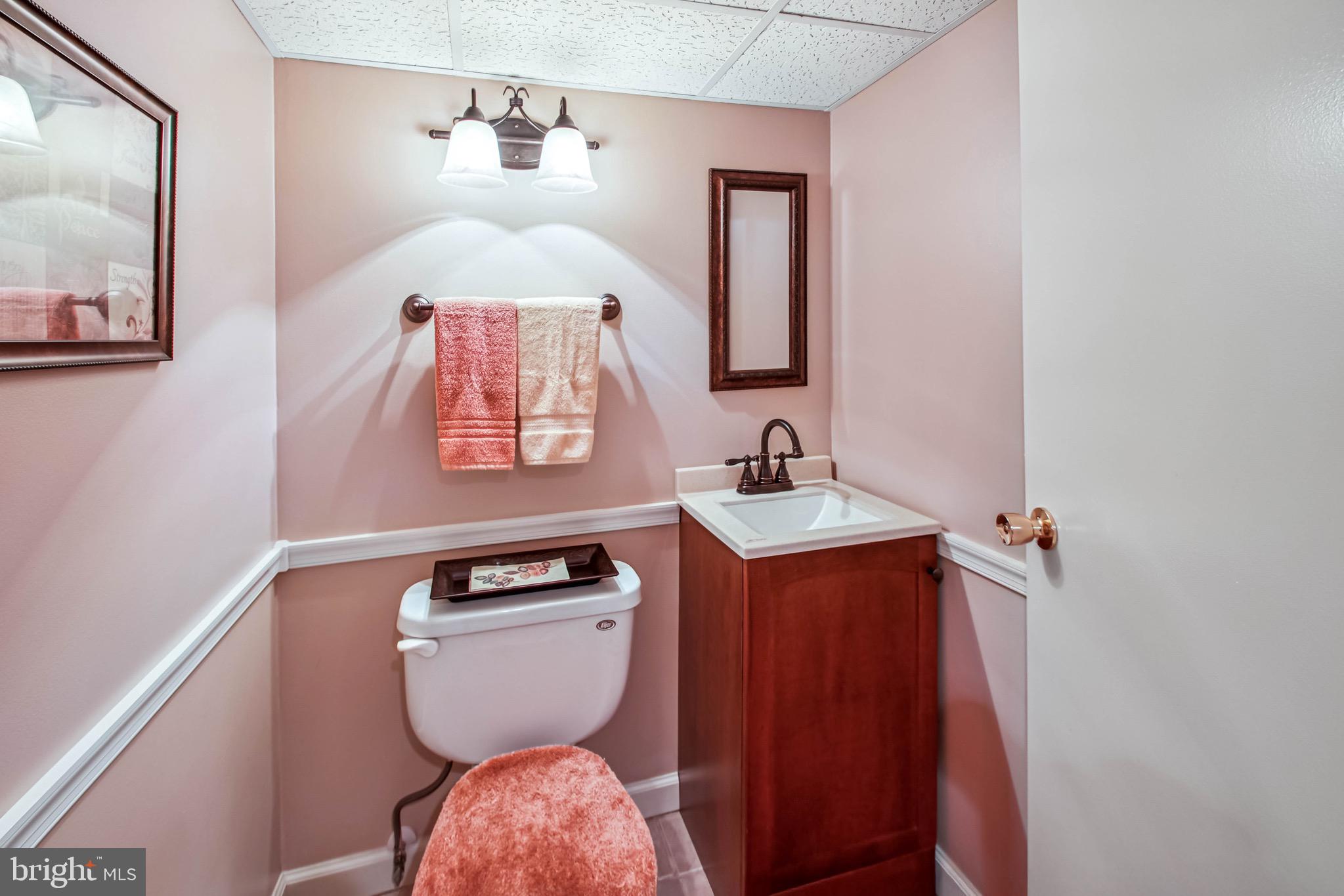 8113 Callo Lane Rosedale, MD 21237 - Photo 31 of 32 a bathroom with a toilet a sink and mirror