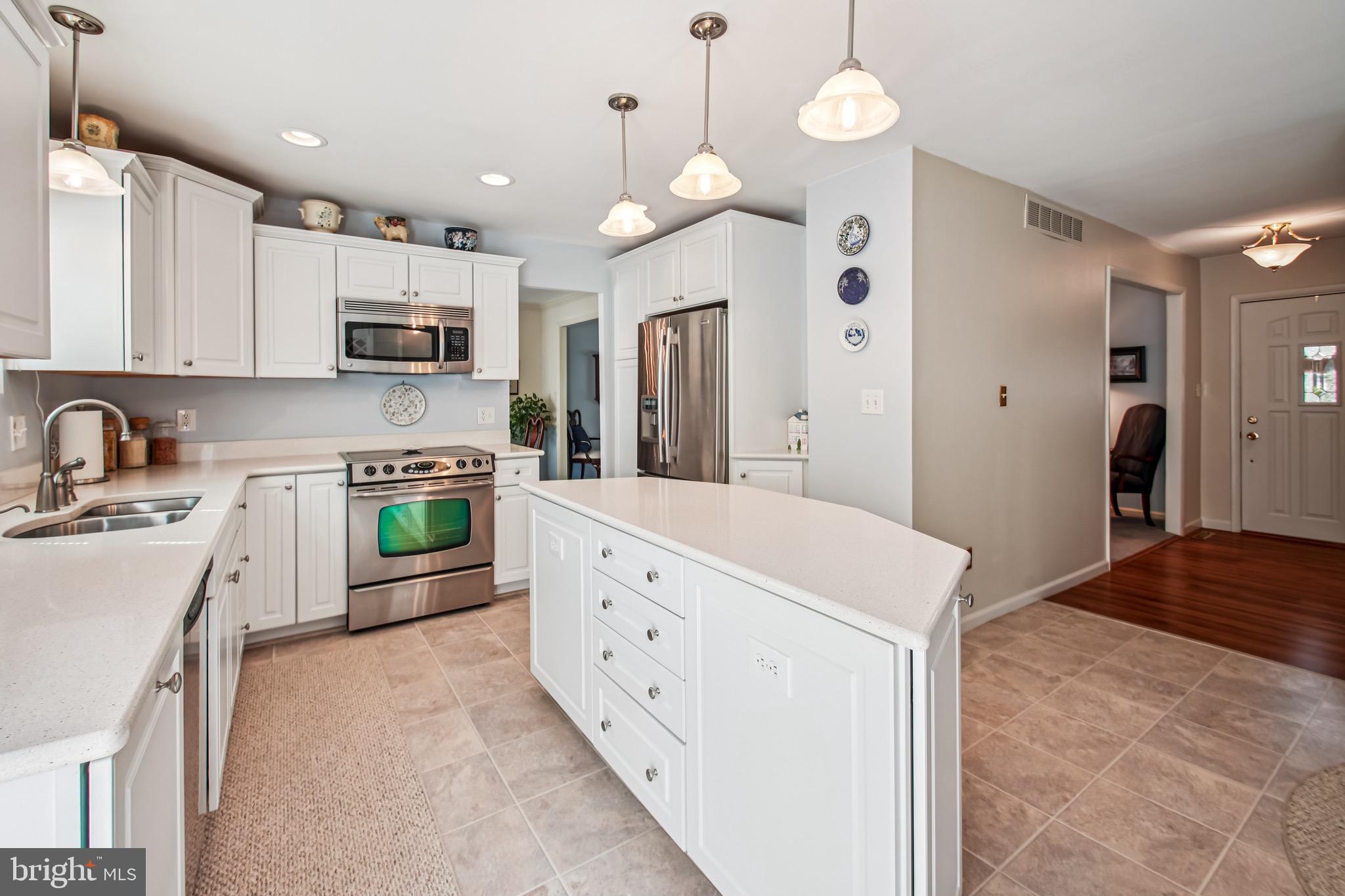 8113 Callo Lane Rosedale, MD 21237 - Photo 9 of 32 a kitchen with stainless steel appliances a stove a sink a refrigerator a center island and cabinets