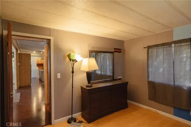 a view of a bedroom with wooden floor and cabinet