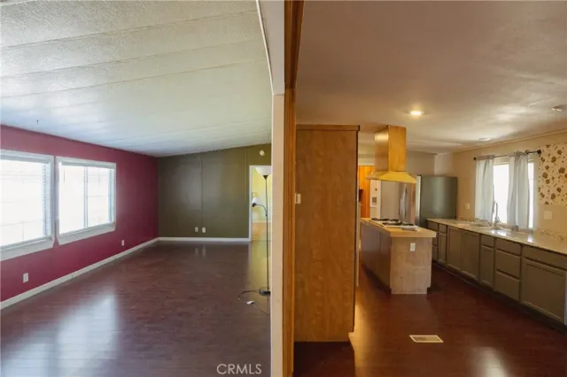a view of hallway with stainless steel appliances granite countertop a refrigerator and a window
