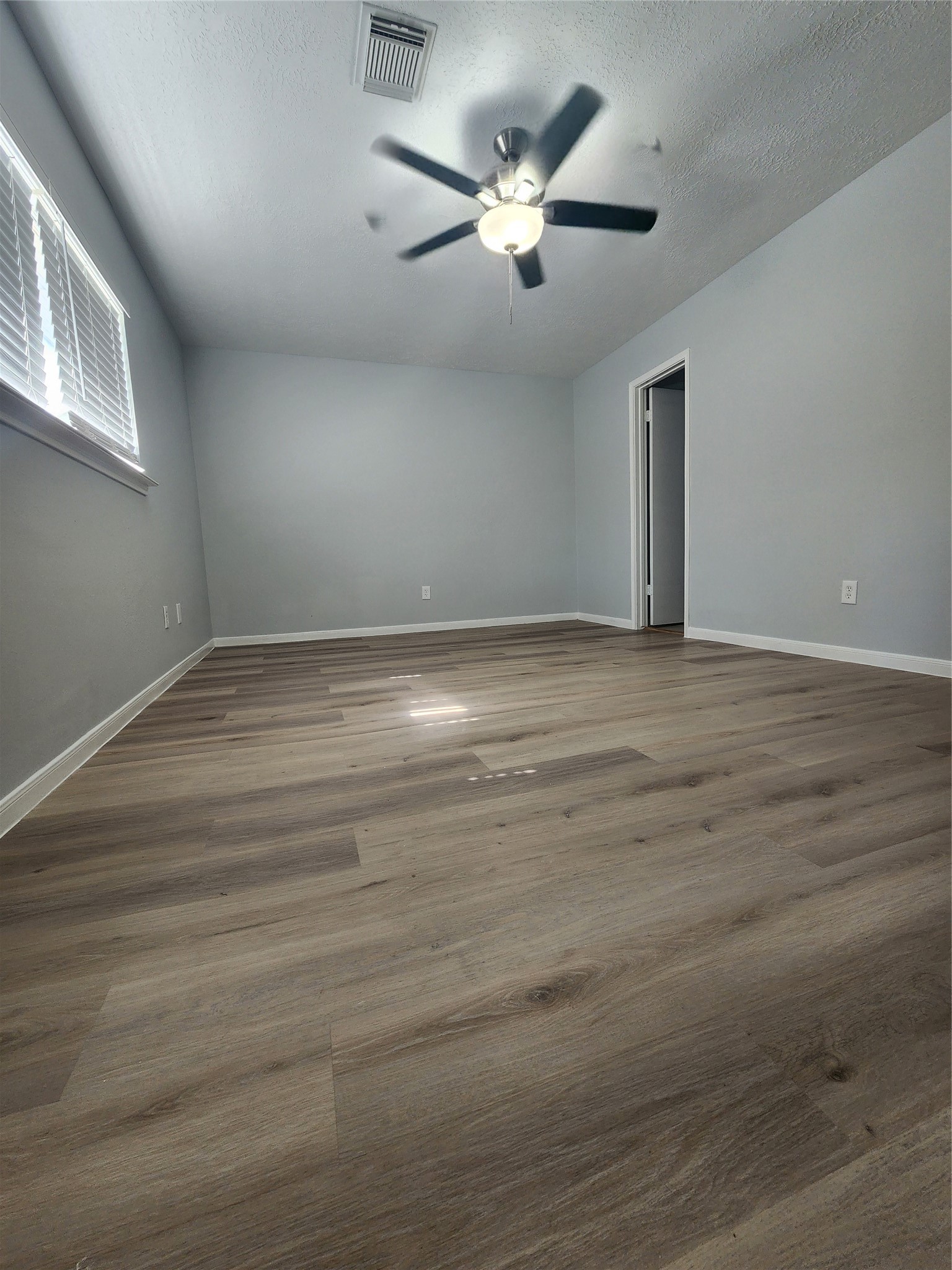 5507 Clarkston Lane Spring, TX 77379 - Photo 11 of 25 a view of an empty room with chandelier fan and wooden floor