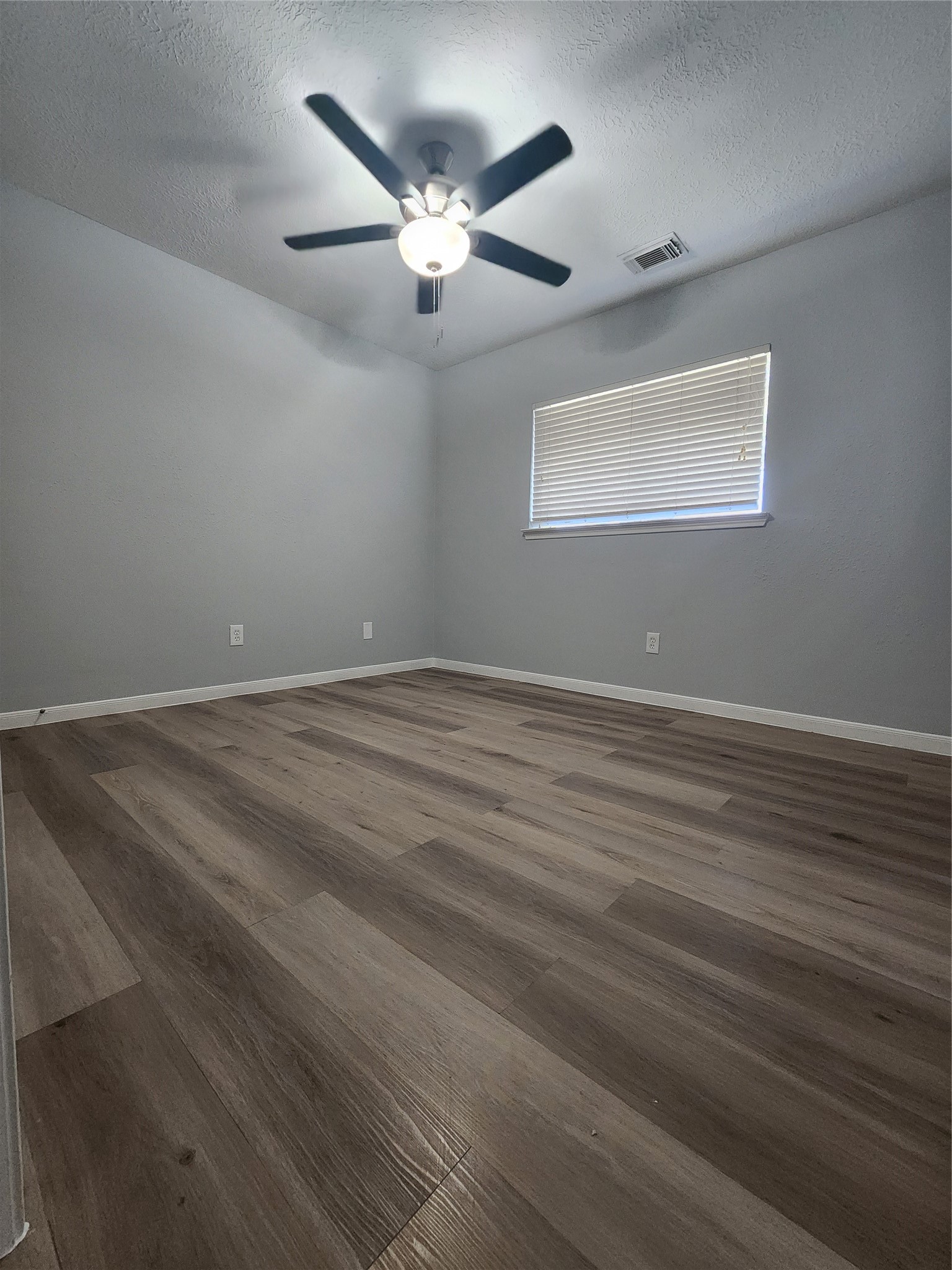 5507 Clarkston Lane Spring, TX 77379 - Photo 19 of 25 an empty room with wooden floor chandelier fan and windows