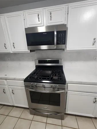 a stove top oven sitting inside of a kitchen
