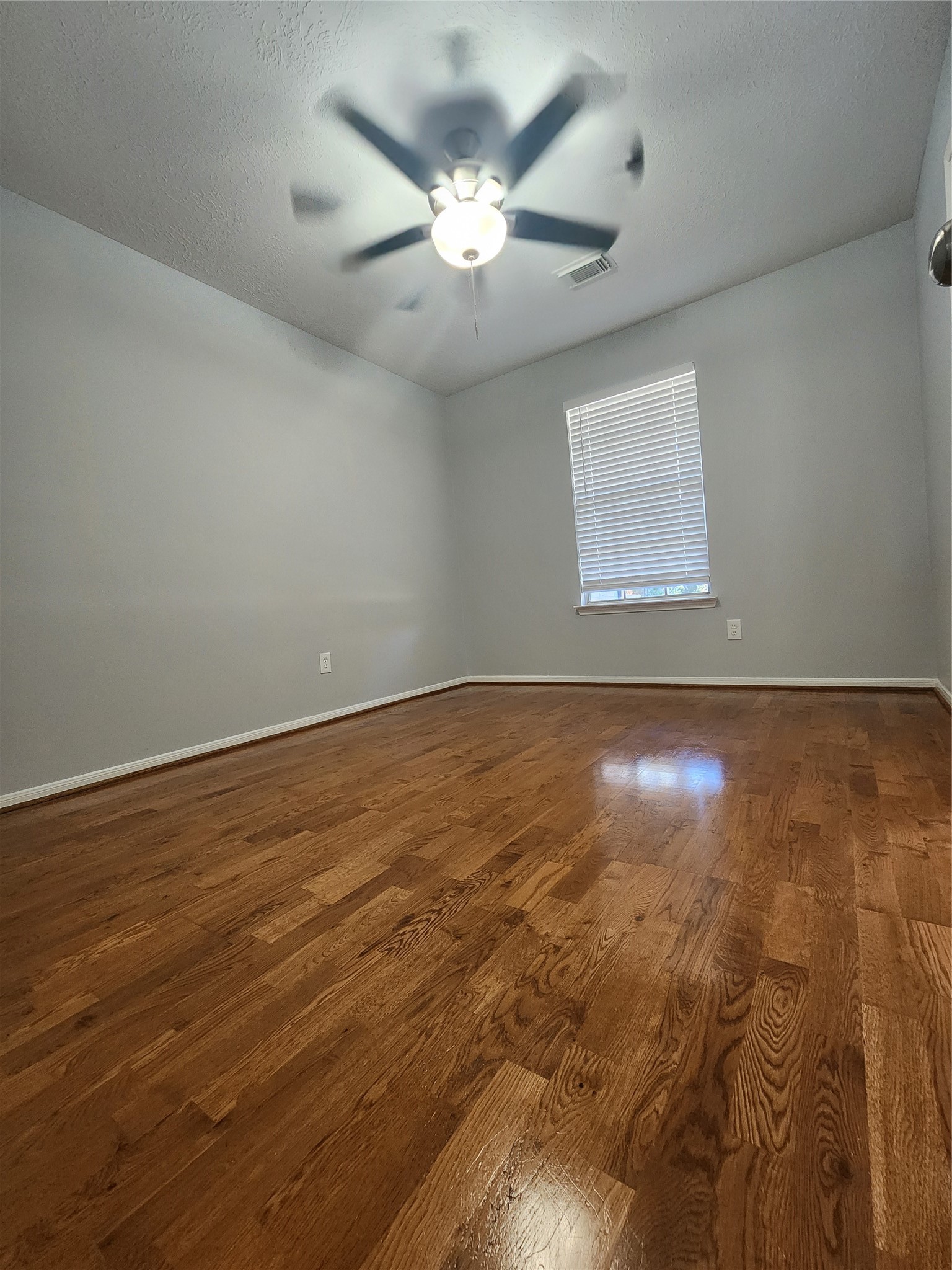 5507 Clarkston Lane Spring, TX 77379 - Photo 10 of 25 an empty room with wooden floor and ceiling fan