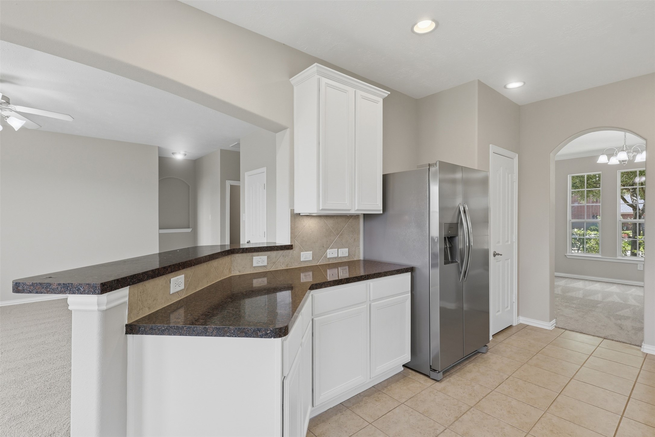 25926 Morgan Springs Spring, TX 77373 - Photo 13 of 49 Another view of the kitchen highlights the open-concept design, plentiful cabinet storage, generous prep space, and convenient breakfast bar, offering the perfect gathering place for family and guests. Tall custom with cabinets! Direct entry into the elegant formal dining room!
