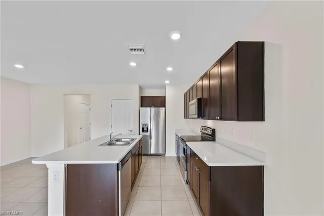 a view of kitchen with stainless steel appliances a refrigerator sink and cabinets