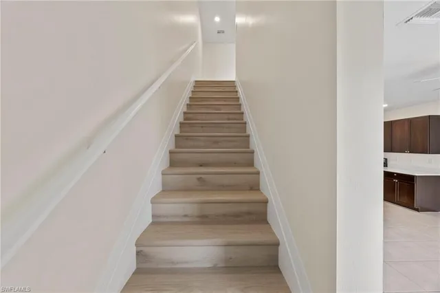 a view of a big room with kitchen and chandelier fan