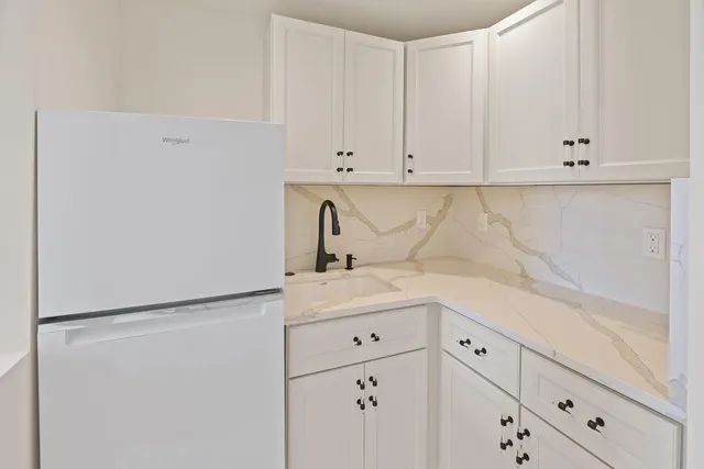 a kitchen with white cabinets and white appliances