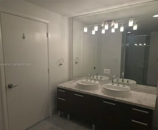 a bathroom with a sink a light fixture and a mirror