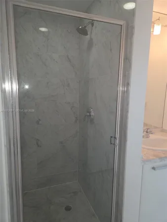 a bathroom with a glass shower door