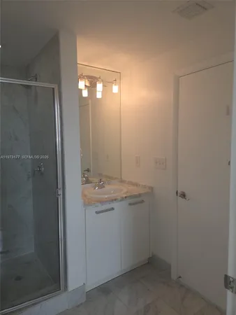 a bathroom with a shower a sink and mirror