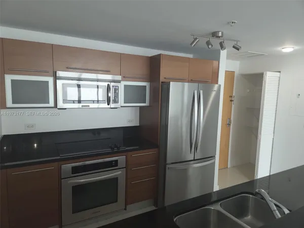 a kitchen with stainless steel appliances granite countertop a refrigerator and a sink