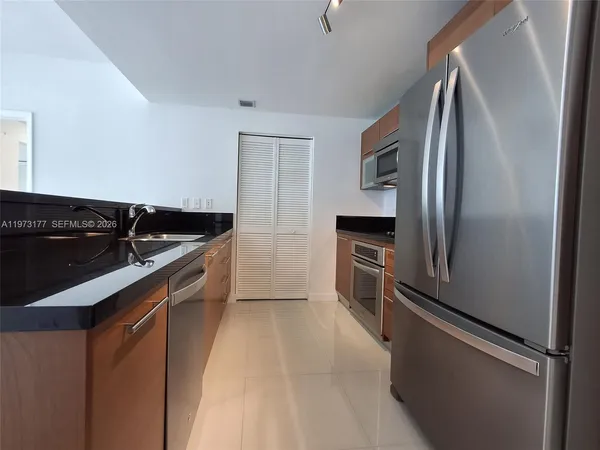 a kitchen with stainless steel appliances granite countertop a refrigerator and a sink