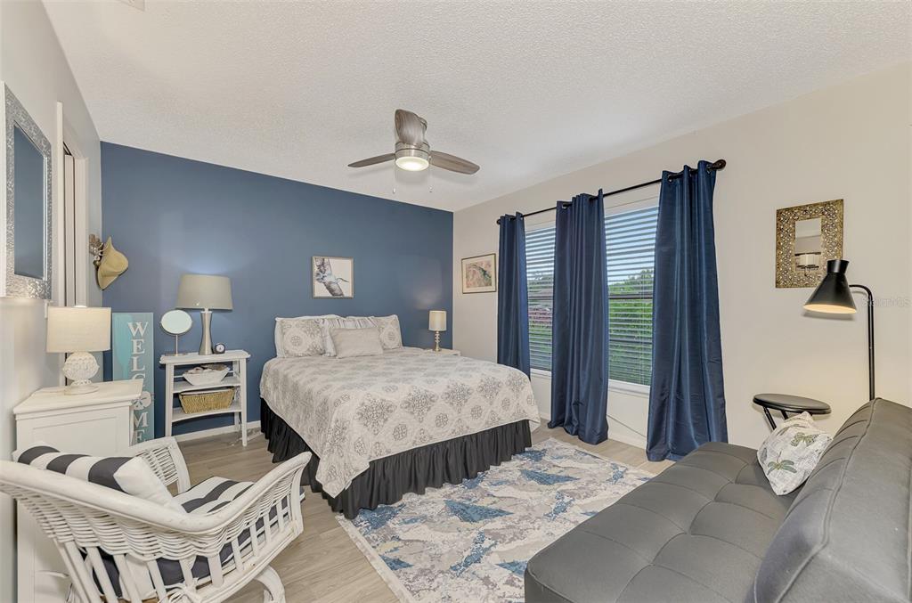 5103 Greencroft Road Sarasota, FL 34235 - Photo 11 of 25 a bedroom with a large bed and a chandelier