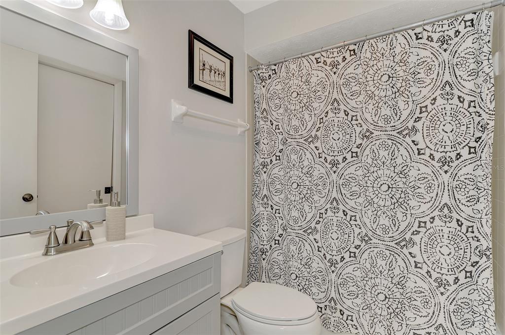5103 Greencroft Road Sarasota, FL 34235 - Photo 12 of 25 a bathroom with a sink a toilet and shower curtain