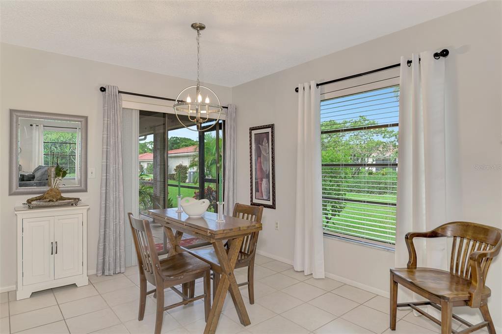 5103 Greencroft Road Sarasota, FL 34235 - Photo 6 of 25 a dining room with furniture a chandelier and window