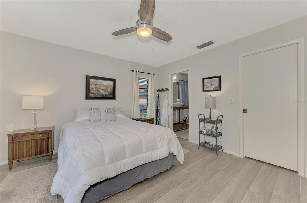 5103 Greencroft Road Sarasota, FL 34235 - Photo 10 of 25 a bedroom with a bed and a chandelier