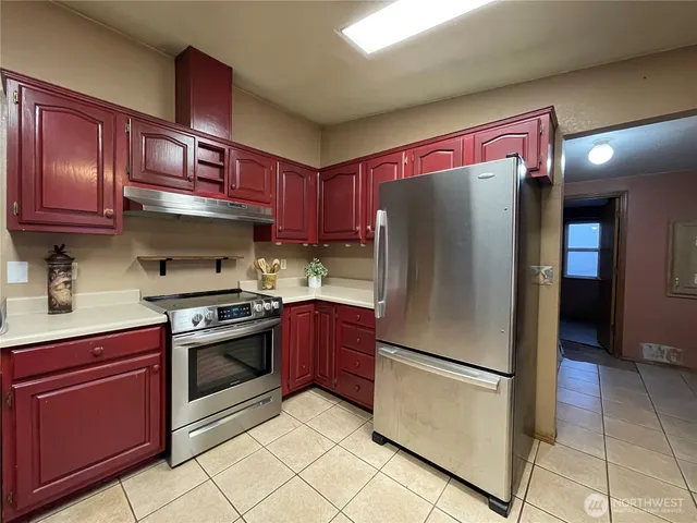 a kitchen with stainless steel appliances granite countertop a refrigerator stove top oven a sink and dishwasher