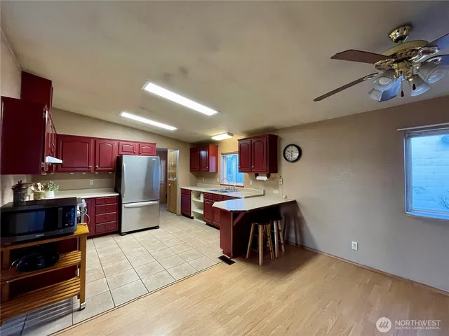 a kitchen with stainless steel appliances kitchen island granite countertop a table chairs and a refrigerator