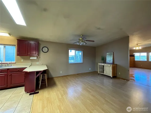 a kitchen with stainless steel appliances granite countertop a sink dishwasher and a stove with wooden floor