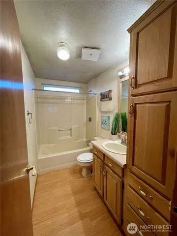 a bathroom with a double vanity sink toilet mirror and shower