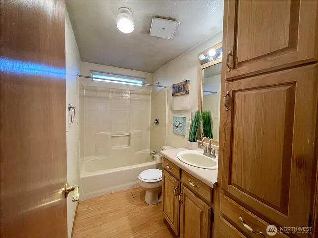a bathroom with a sink a toilet a mirror and shower