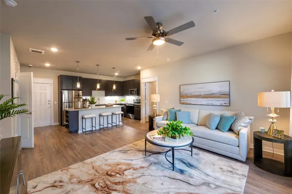 a living room with furniture and kitchen view