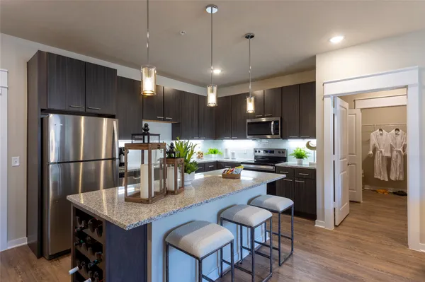 a kitchen with refrigerator and chairs