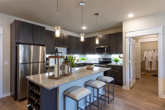 a kitchen with refrigerator and chairs
