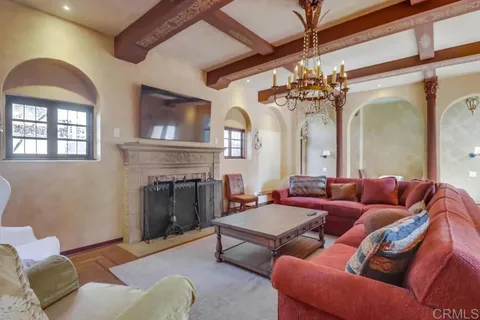 a dining room with furniture a chandelier and wooden floor