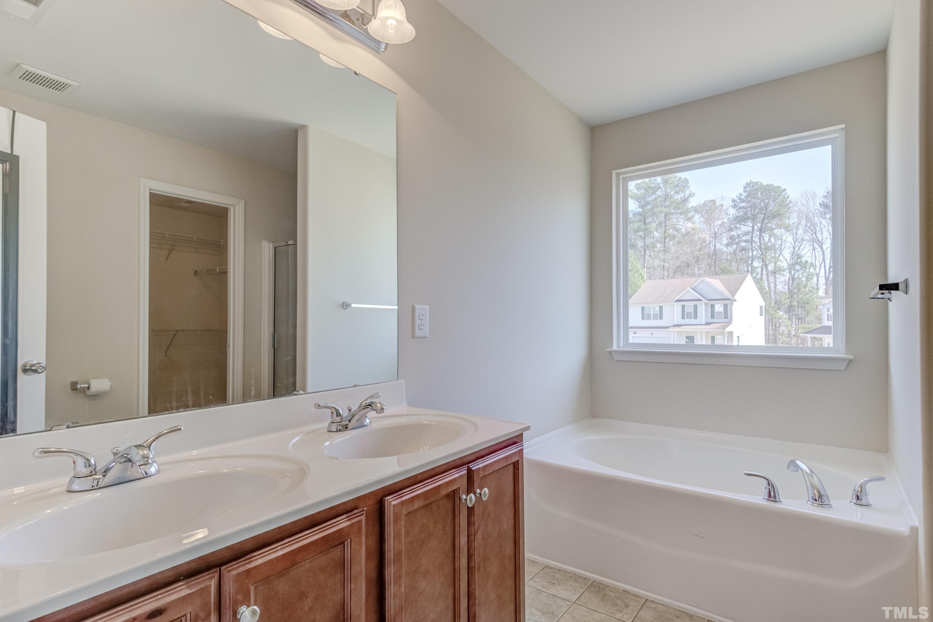 2925 Filbert Street Raleigh, NC 27610 - Photo 14 of 21 a bathroom with a granite countertop sink a large mirror a and a bathtub